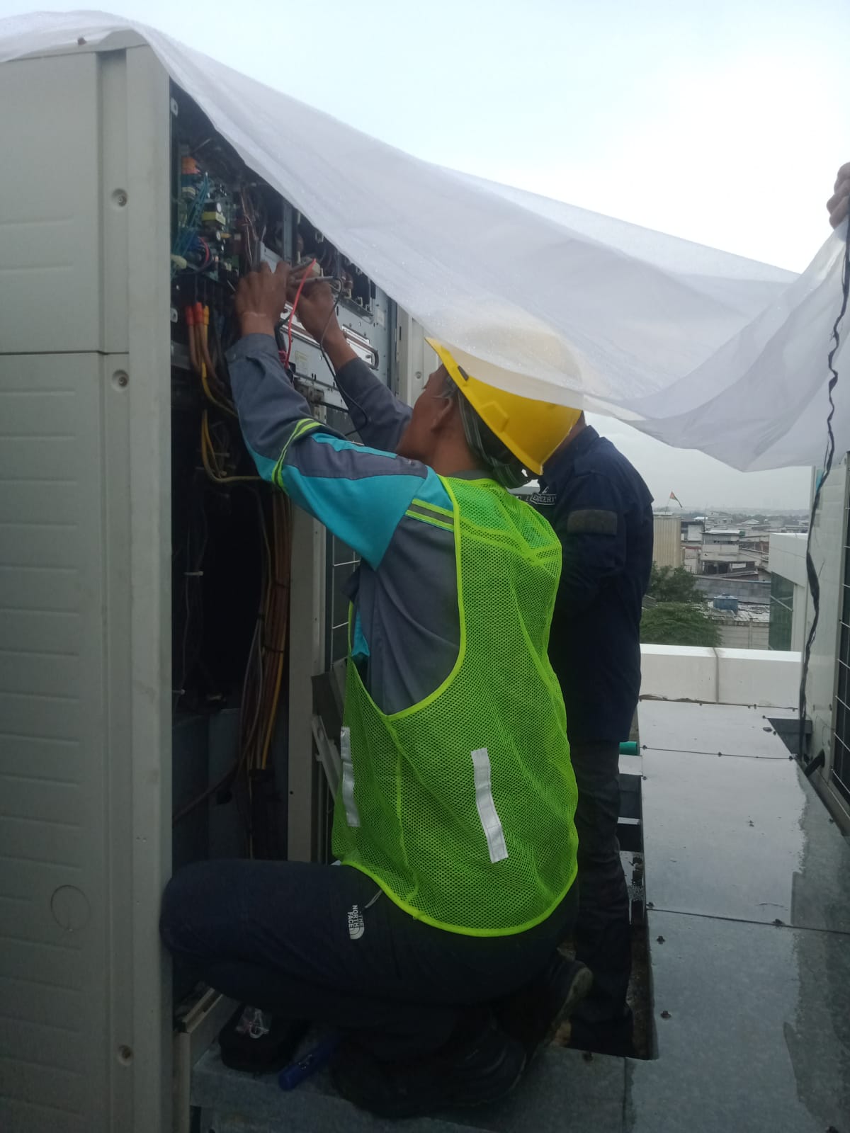 Teknisi Bangkit Berseri Teknik sedang memperbaiki unit AC VRV di atap gedung, Karawang